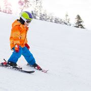 Bambino sulla pista da sci con il casco