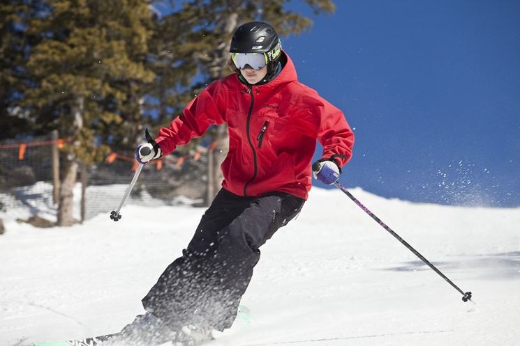 Atleta di sci in discesa con giacca tecnica