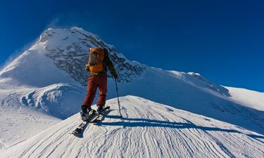 Snowboarder impegnato in una salita con la Splitboard aperta